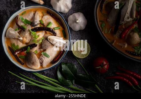 Poulet Tom yum avec Chili, coriandre, piment séché, feuilles de citron vert kaffir, champignons et citronnelle dans un bol Banque D'Images