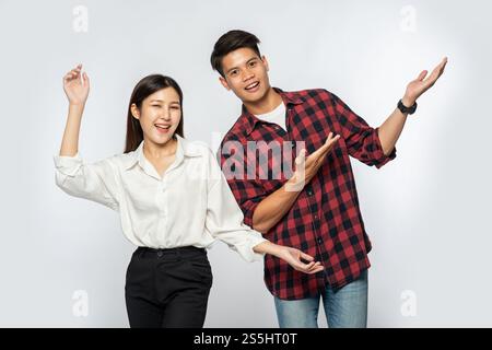Les hommes et les femmes portaient des chemises et tenaient heureusement leurs mains sur le côté. Banque D'Images