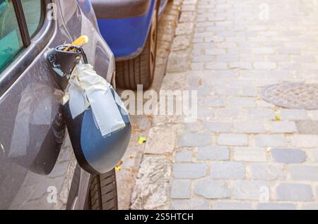 Vue rapprochée du rétroviseur de voiture cassé ou du rétroviseur d'aile sur la porte, accident de la route de ville Banque D'Images