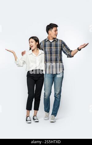 Les hommes et les femmes portaient des chemises et tenaient heureusement leurs mains sur le côté. Banque D'Images