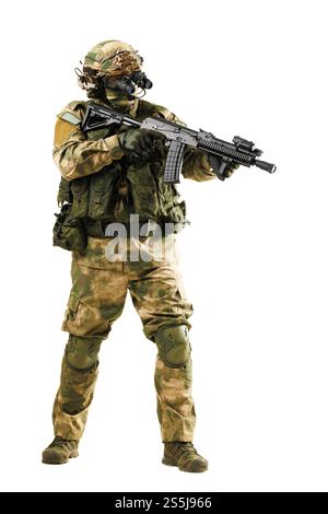 Soldat armé en camouflage et équipement tactique équipé d'armes debout sur fond blanc. Banque D'Images
