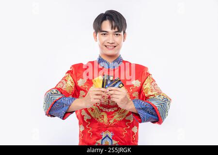 Man Wear cheongsam porte plusieurs cartes de crédit pour aller faire du shopping pendant le nouvel an chinois. Banque D'Images
