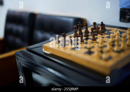 Jeu d'échecs en cours sur une planche de bois dans un coin salon calme Banque D'Images
