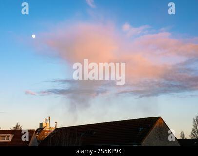 Petite douche hivernale avec de belles stries d'automne (virga) est magnifiquement illuminée rose orange par le soleil couchant d'hiver Banque D'Images