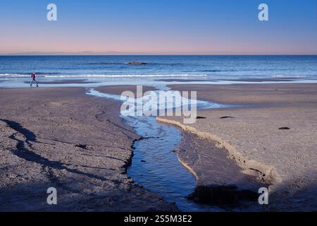 La photo capture un moment serein et paisible au Moray Firth en Écosse. Les vagues douces caressent le rivage, créant une mélodie apaisante qui Banque D'Images