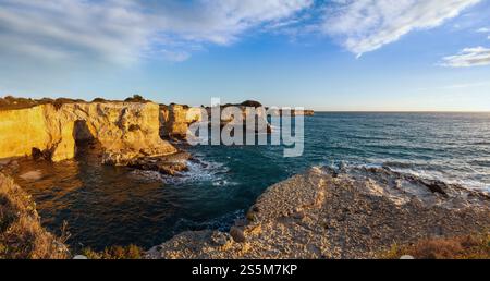 Seascape pittoresque avec des falaises rocheuses, arch et piles (faraglioni), à Torre Sant'Andrea dans la lumière du soleil du matin, la côte de la mer du Salento, Pouilles, Italie. Banque D'Images