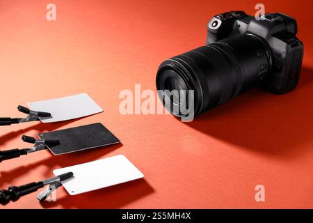 Cartes de calibrage de la balance des blancs et caméra sur fond rouge Banque D'Images