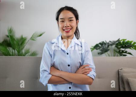 Portrait jeune femme asiatique debout et les bras croisés sur la poitrine, regardant la caméra avec le sourire, espace de copie Banque D'Images