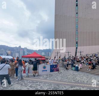 Hong Kong - 16 novembre 2024 : Un espace public extérieur animé, peut-être une place ou une place, dispose d'un grand bâtiment moderne et de nombreuses personnes enjo Banque D'Images