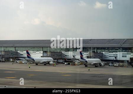 Une vue de deux avions commerciaux modernes stationnés au terminal de l'aéroport international de Bogota. L'image capture l'activité animée sur le ta Banque D'Images