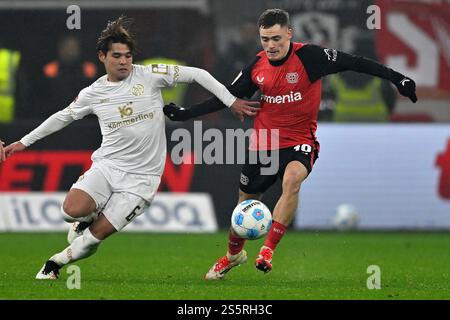 Leverkusen, Allemagne. 14 janvier 2025. Florian Wirtz (R) de Bayer 04 Leverkusen affronte Sano Kaishu de 1.FSV Mainz 05 lors du match de première division de Bundesliga entre Bayer 04 Leverkusen et 1.FSV Mainz 05 à Leverkusen, Allemagne, le 14 janvier 2025. Crédit : Ulrich Hufnagel/Xinhua/Alamy Live News Banque D'Images