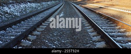 Détails chemin de fer d'hiver russe enneigé sous la lumière du soleil. Les rails et les traverses sous la neige de décembre. Chemins de fer russes en détail. Hiver Banque D'Images