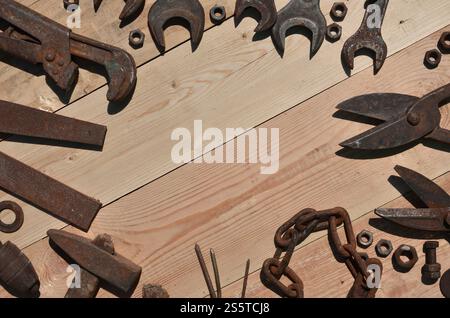 Un ensemble d'outils vieux et rouillés pour bricoleur. Beaucoup d'outils ménagers obsolètes en métal rouillé reposent sur une table en bois dans l'atelier. Le concept de Banque D'Images