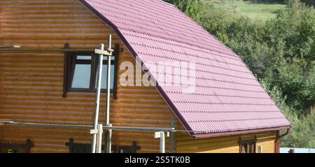 Maison avec un toit en feuilles de métal solide, formé comme une vieille tuile Banque D'Images