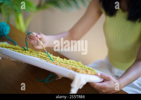 Aiguille perforée. Femme asiatique faisant tricoter Hobby à la main dans l'atelier de studio. Designer Workplace projet artisanal fait à la main concept de broderie DIY Banque D'Images