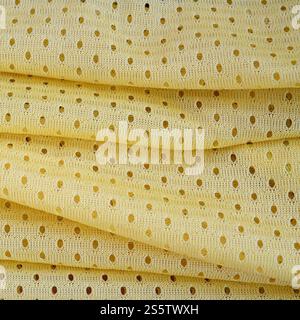 Fond de modèle textile de tissu de tissu de sport de maille jaune. Couleur jaune maillot de football vêtements tissu texture vêtements de sport. Poreux respirant Banque D'Images