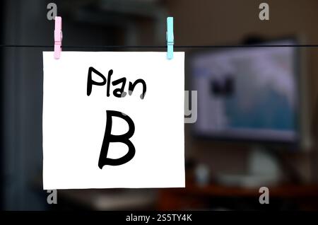Plan B. Note est écrit sur un autocollant blanc qui est suspendu avec une pince à linge sur une corde sur un fond d'intérieur de bureau Banque D'Images