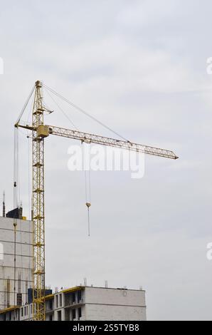 Grues hautes de travail à l'intérieur de l'endroit pour avec des bâtiments hauts en construction contre un ciel bleu clair. Grue et construction progression du travail avec Banque D'Images