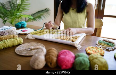 Aiguille perforée. Femme asiatique faisant tricoter Hobby à la main dans l'atelier de studio. Designer Workplace projet artisanal fait à la main concept de broderie DIY Banque D'Images