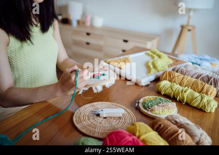 Aiguille perforée. Femme asiatique faisant tricoter Hobby à la main dans l'atelier de studio. Designer Workplace projet artisanal fait à la main concept de broderie DIY Banque D'Images