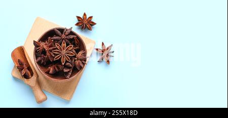 Bol en bois et cuillère avec anis étoilé aromatique sur fond bleu clair avec espace pour le texte, vue de dessus Banque D'Images