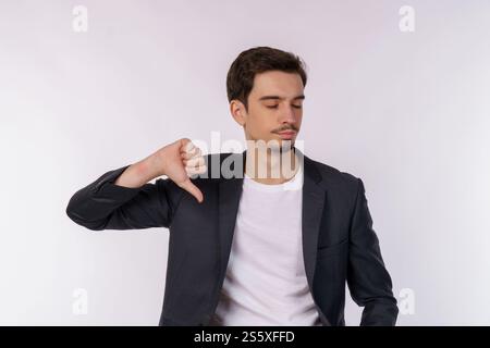 Portrait de jeune homme d'affaires montre le signe de l'aversion, regarde avec l'expression négative et la désapprobation sur fond isolé. Désaccord, dégoût et Banque D'Images