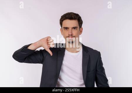 Portrait de jeune homme d'affaires montre le signe de l'aversion, regarde avec l'expression négative et la désapprobation sur fond isolé. Désaccord, dégoût et Banque D'Images