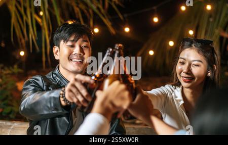 Portrait d'amis asiatiques heureux ayant dîner ensemble - jeunes assis à la table de bar toast verres à bière dîner en plein air - les gens, la nourriture, Banque D'Images