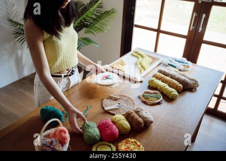 Aiguille perforée. Femme asiatique faisant tricoter Hobby à la main dans l'atelier de studio. Designer Workplace projet artisanal fait à la main concept de broderie DIY Banque D'Images