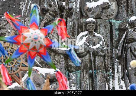 LVIV, UKRAINE - 12 JANVIER 2025 - des étoiles Carolines sont vues sur fond de la stèle symbolique de 12 mètres avec des bas-reliefs "vague de renouveau national" situé à gauche du monument à Taras Shevchenko, où le festival régional du folklore hivernal ukrainien "Nouvelle joie vient. Rozkoliada” a lieu, Lviv, ouest de l’Ukraine Banque D'Images