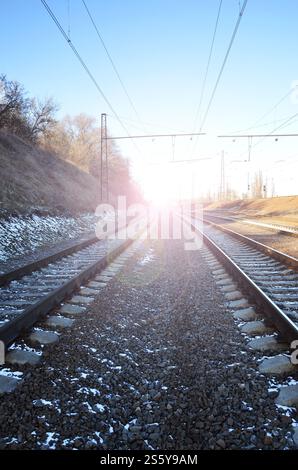 Paysage de neige d'un hiver russe sous la vive lumière du soleil les rails et traverses sous la neige de décembre. Les chemins de fer russes en détail Banque D'Images