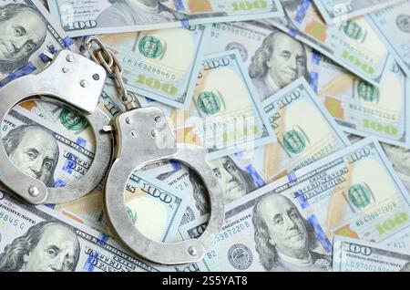 Les menottes de police argentées se trouvent sur de nombreux billets d'un dollar. Les menottes de police argentées se trouvent sur de nombreux billets d'un dollar Banque D'Images