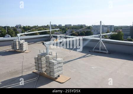 Contrepoids ou équilibrage de poids blocs de béton ou de briques faisant partie de la plate-forme suspendue de câble métallique pour les travaux de façade sur des bâtiments à plusieurs étages élevés. Banque D'Images