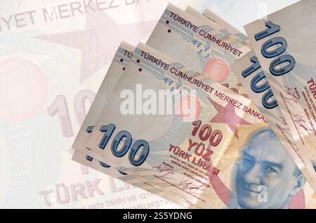 100 billets de lires turques se trouve en pile sur fond de gros billet semi-transparent. Présentation abstraite de la monnaie nationale. Concept commercial. Banque D'Images
