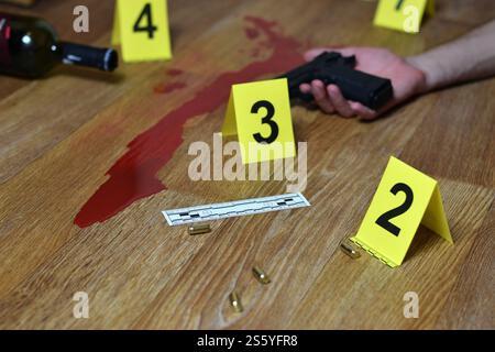 Scène de crime sanglante avec cadavre et arme à feu sur le sol. De nombreux marqueurs d'enquête sur les lieux de crime à l'intérieur se rapprochent. Scène de crime sanglante avec cadavre et Banque D'Images