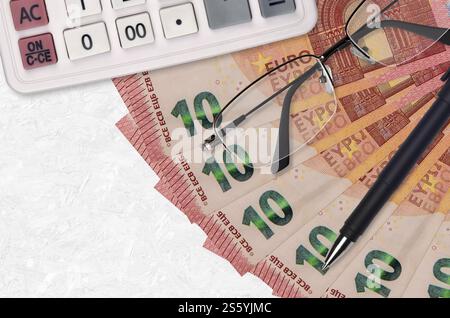 ventilateur de billets de 10 euros et calculatrice avec lunettes et stylo. Concept de prêt commercial ou de saison de paiement d'impôt. Planification financière. ventilateur de billets de 10 euros et Banque D'Images