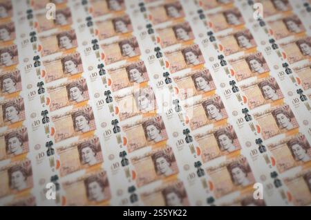 Billets de 10 livres sterling imprimés dans un convoyeur de production d'argent illégal. Collage de nombreux faux billets. Concept de travail de masse des contrefacteurs. 10 Britanniques Banque D'Images