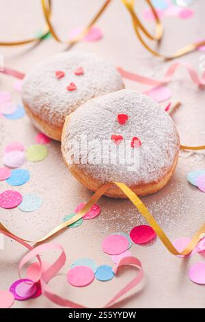 Fond coloré de carnaval ou de fête avec des beignets, des streamers et des confettis Banque D'Images