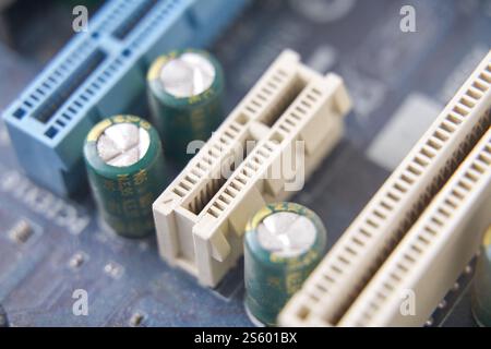 Gros plan sur la carte mère de l'ordinateur avec les condensateurs et les emplacements pci en évidence. Banque D'Images
