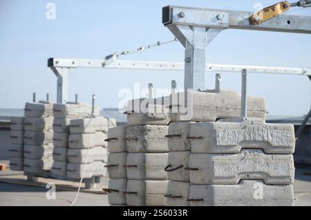 Contrepoids ou équilibrage de poids blocs de béton ou de briques faisant partie de la plate-forme suspendue de câble métallique pour les travaux de façade sur des bâtiments à plusieurs étages élevés. Banque D'Images