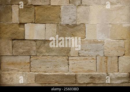 Texture d'un mur de pierre avec beaucoup de grosses pierres brunes et grises armées de ciment. Vieux château mur de pierre texture fond pour usage médiéval. Partie d'un Banque D'Images