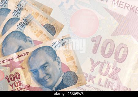 100 billets de lires turques se trouve en pile sur fond de gros billet semi-transparent. Fond d'entreprise abstrait avec espace de copie. 100 livres turques Banque D'Images