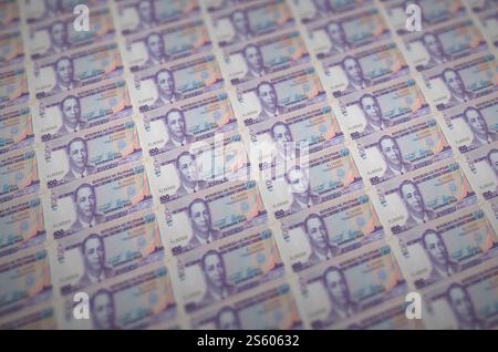 100 billets de piso philippins imprimés dans un convoyeur de production d'argent illégal. Collage de nombreux faux billets. Concept de travail de masse des contrefacteurs. 100 Banque D'Images