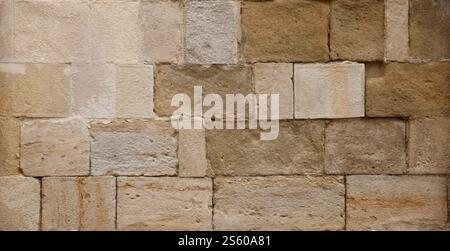 Texture d'un mur de pierre avec beaucoup de grosses pierres brunes et grises armées de ciment. Vieux château mur de pierre texture fond pour usage médiéval. Partie d'un Banque D'Images