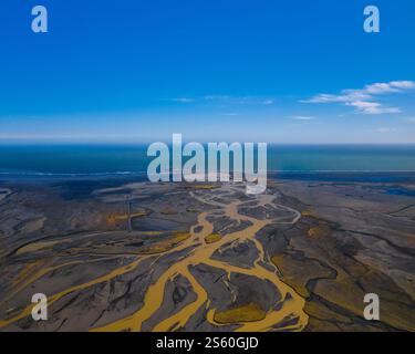 Vue aérienne des rivières tressées et des côtes vibrantes rencontrant l'océan dans le sud de l'Islande Banque D'Images