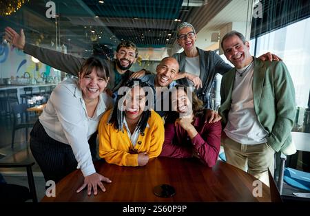 Équipe d'affaires diversifiée souriant et posant dans le bureau moderne à la caméra. Banque D'Images