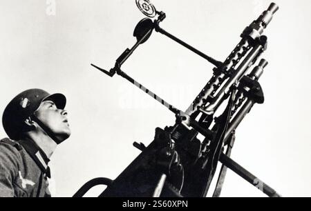 Un soldat allemand manœuvrant des MITRAILLEUSES MG 34 jumelées sur une monture antiaérienne Zwillingssockel 36 pendant la seconde Guerre mondiale. Banque D'Images