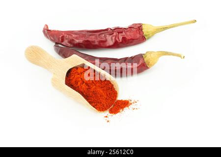Poudre de Chili dans une cuillère en bois avec des piments rouges séchés isolés sur fond blanc Banque D'Images