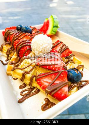 gaufres aux fraises et chocolat aux baies sur un support en carton Banque D'Images