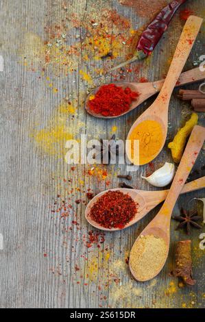 Diverses épices en cuillère sur table rustique en bois gris, fond d'épices Banque D'Images